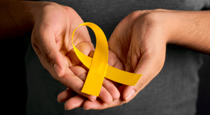 A person holds a yellow ribbon in honor of World Suicide Prevention Day.