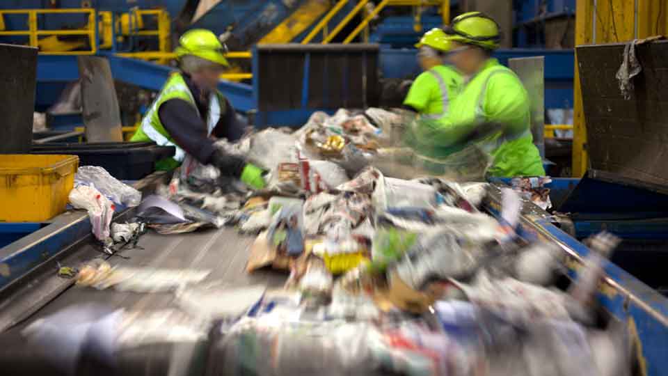 Workers sorting recycling at a municipal recycling facility (MRF)