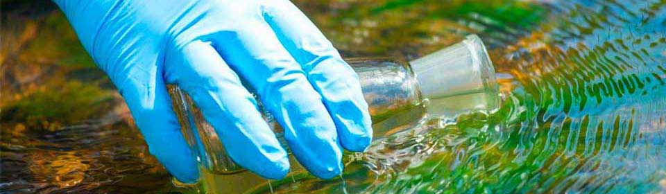Gloved hand taking a water sample