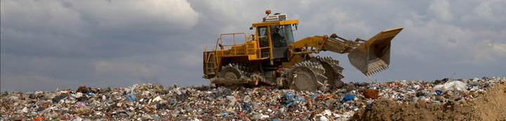 Bulldozer on landfill pushing trash