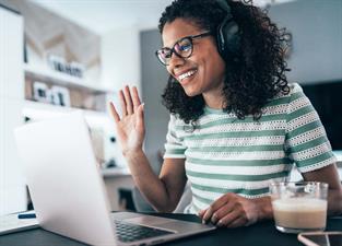 Woman waving at a laptop screen